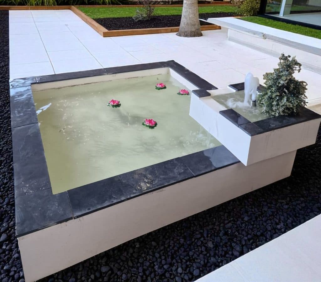 A tranquil garden pool bordered by stonework and greenery